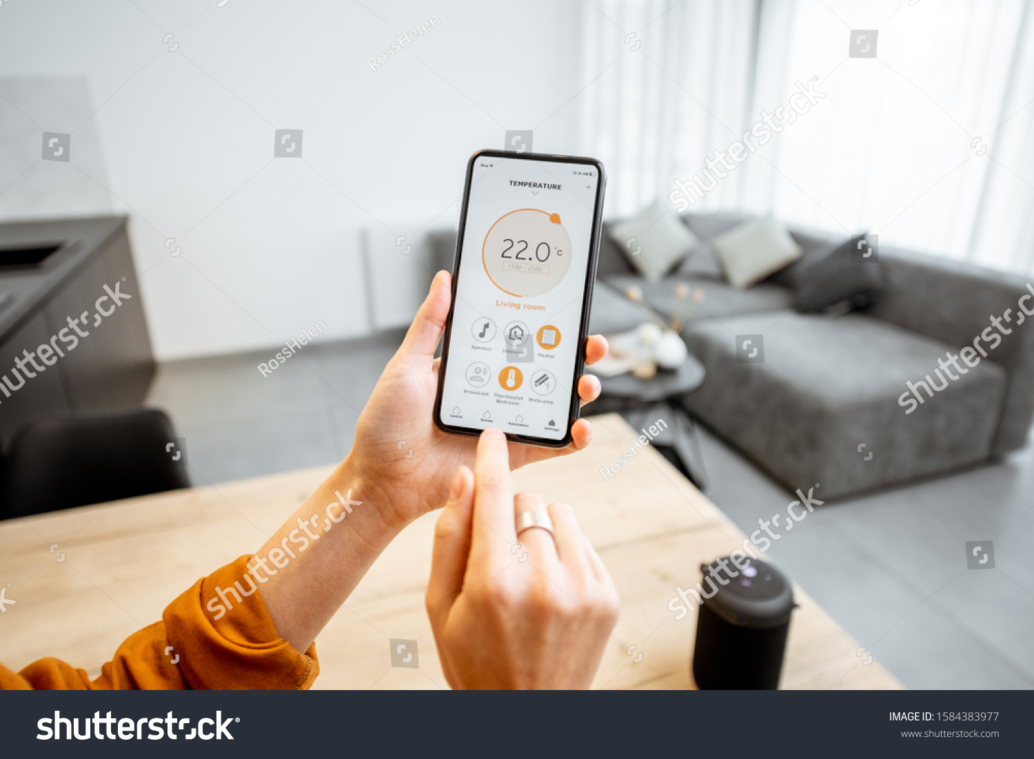 Controlling home heating temperature with a smart home, close-up on phone. Concept of a smart home and mobile application for managing smart devices at home #1584383977
