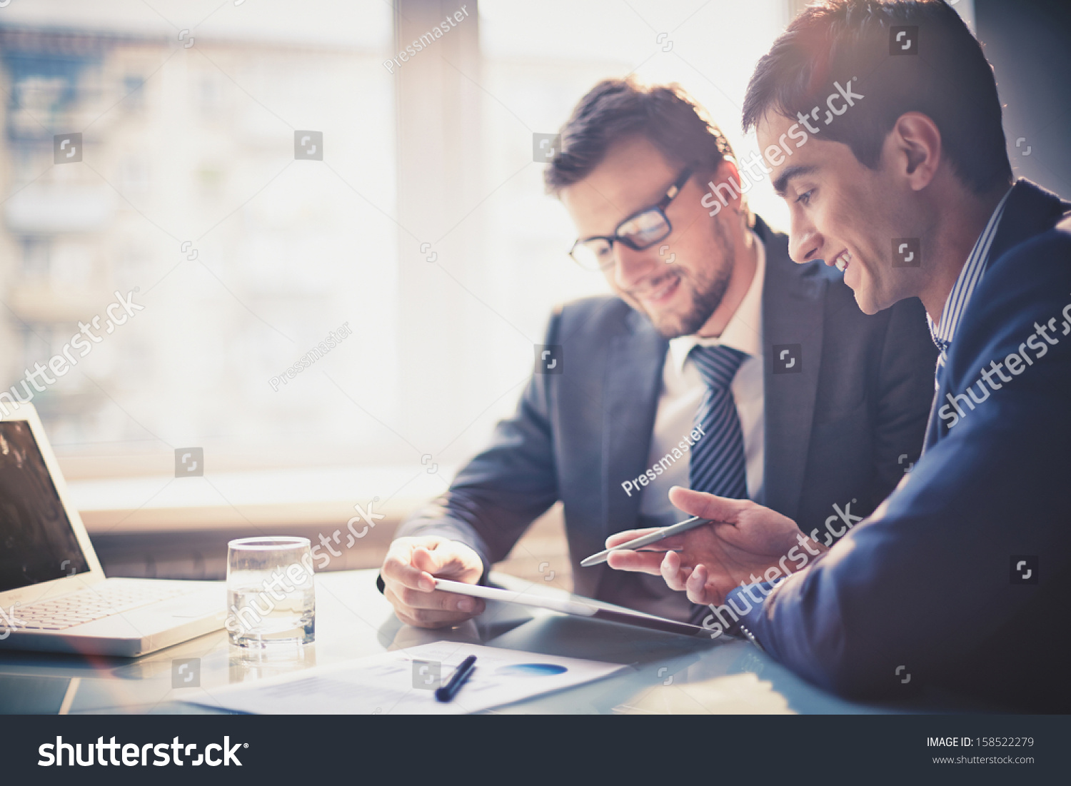 Image of two young businessmen using touchpad at meeting #158522279