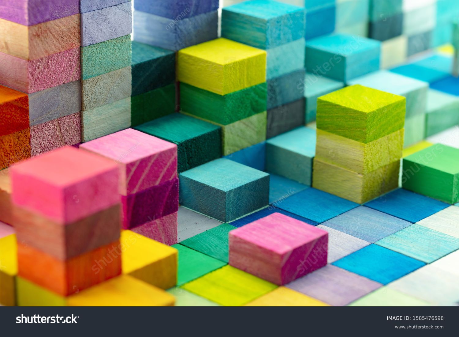 Spectrum of stacked multi-colored wooden blocks. Background or cover for something creative, diverse, expanding,  rising or growing. shallow depth of field. #1585476598