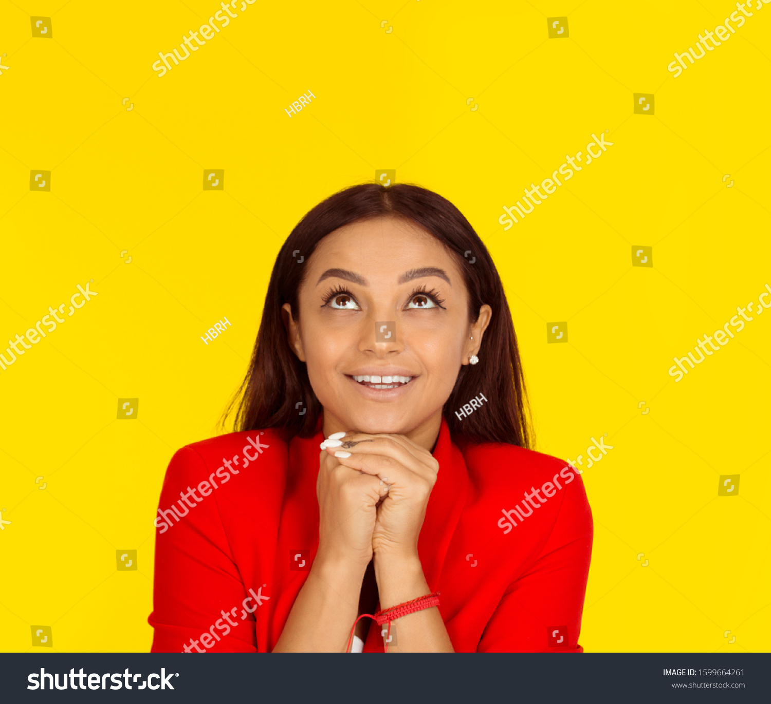 Thinking business woman looking up smiling happy. Mixed race model isolated on yellow background with copy space. Horizontal image. #1599664261