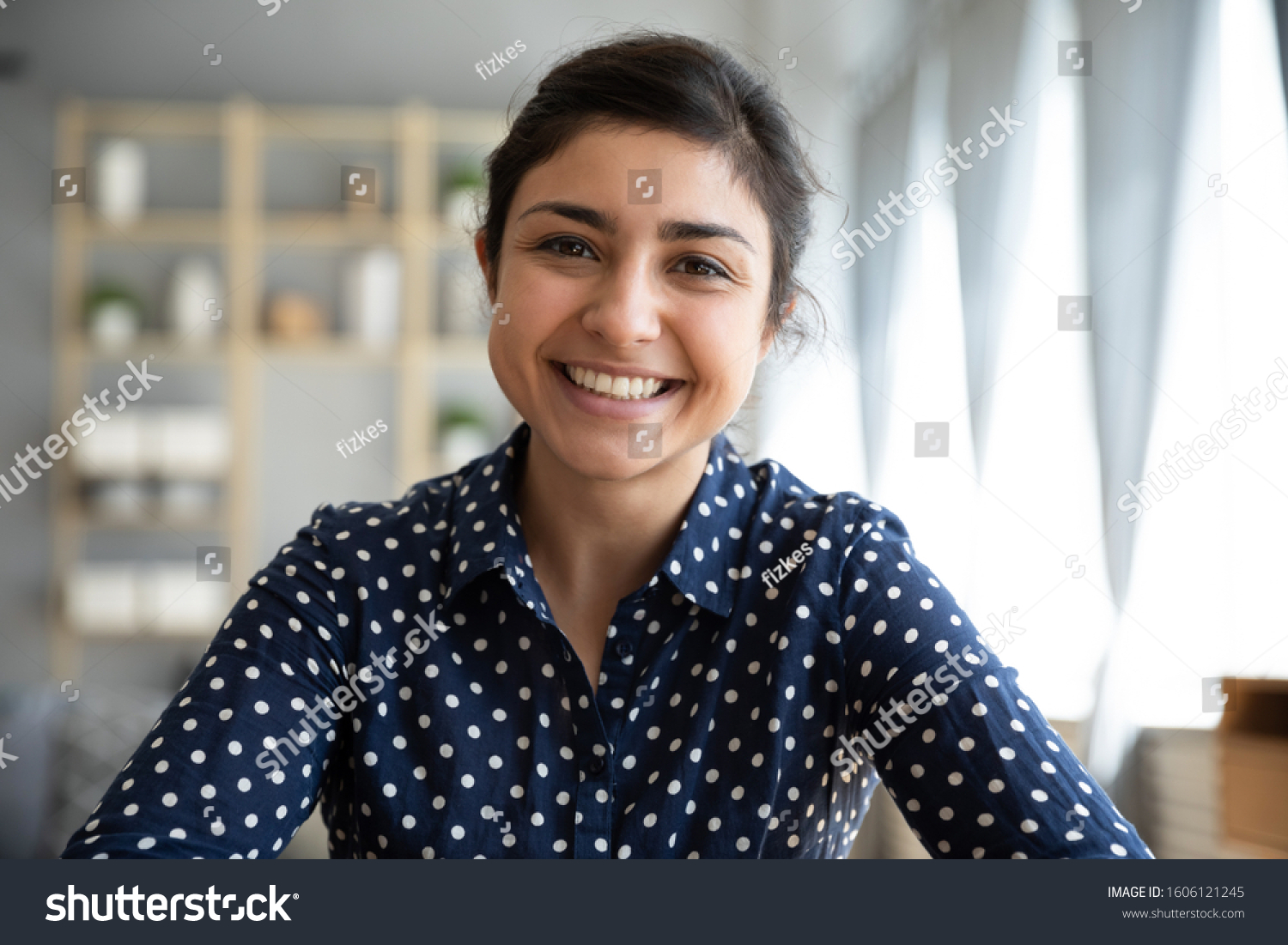 Happy young indian woman blogger applicant teacher sit at home office look at camera doing online job interview during video chat conference call record vlog teaching on webinar in app, webcam view #1606121245