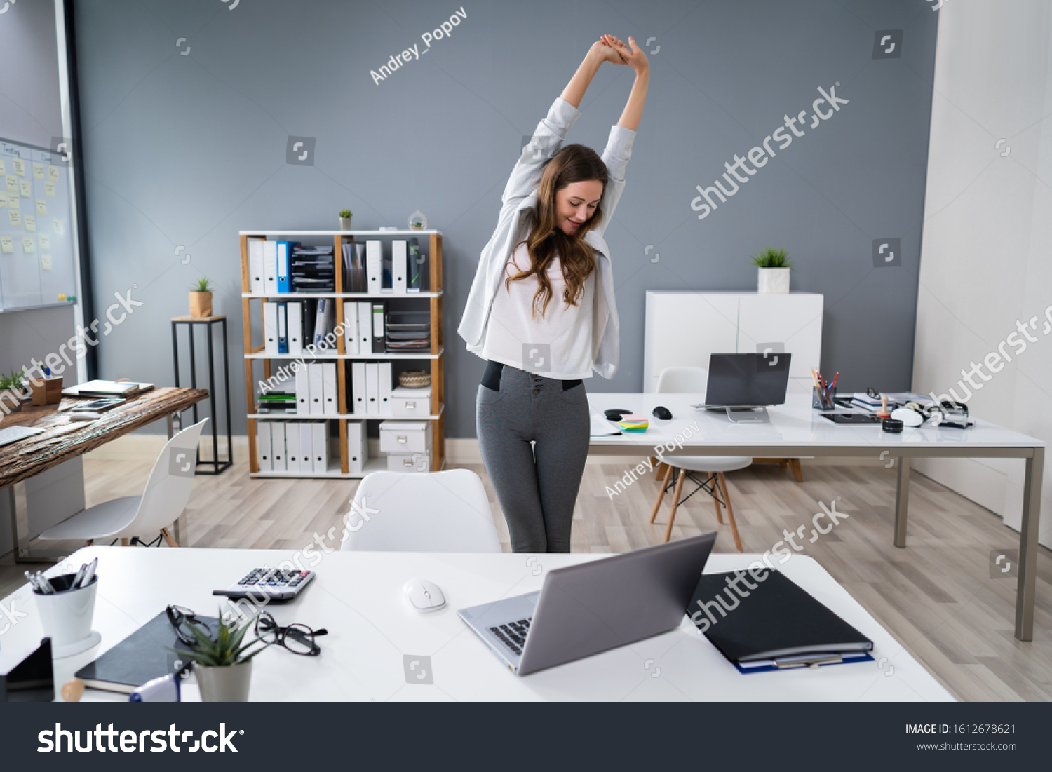 Young Businesswoman Stretching Her Arms At Desk #1612678621