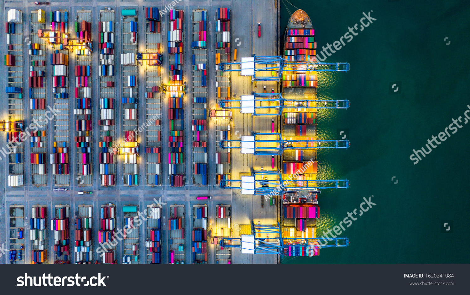 Container ship working at night, Business import export logistic and transportation of International by container ship in the open sea, Aerial view industrial crane loading cargo freight port, Dubai. #1620241084