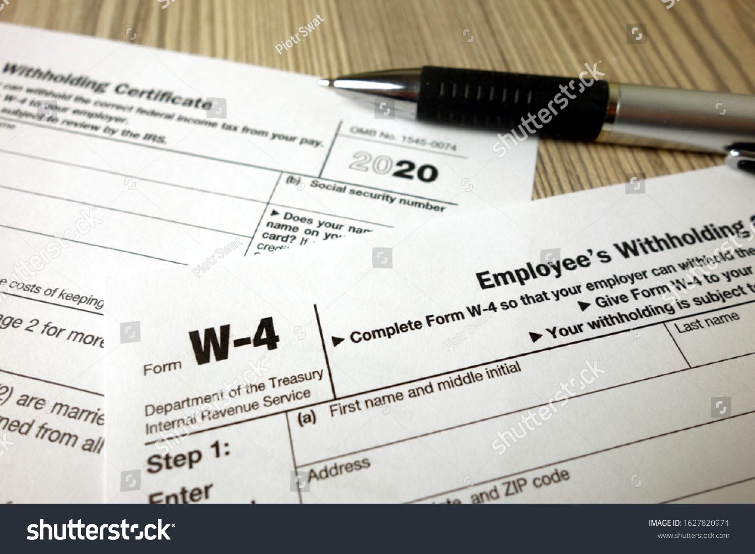 Blank W-4 tax form and a pen. Tax season #1627820974