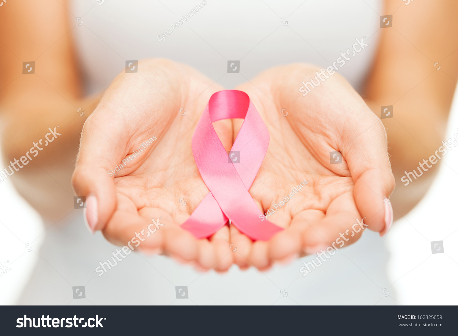 healthcare and medicine concept - womans hands holding pink breast cancer awareness ribbon #162825059