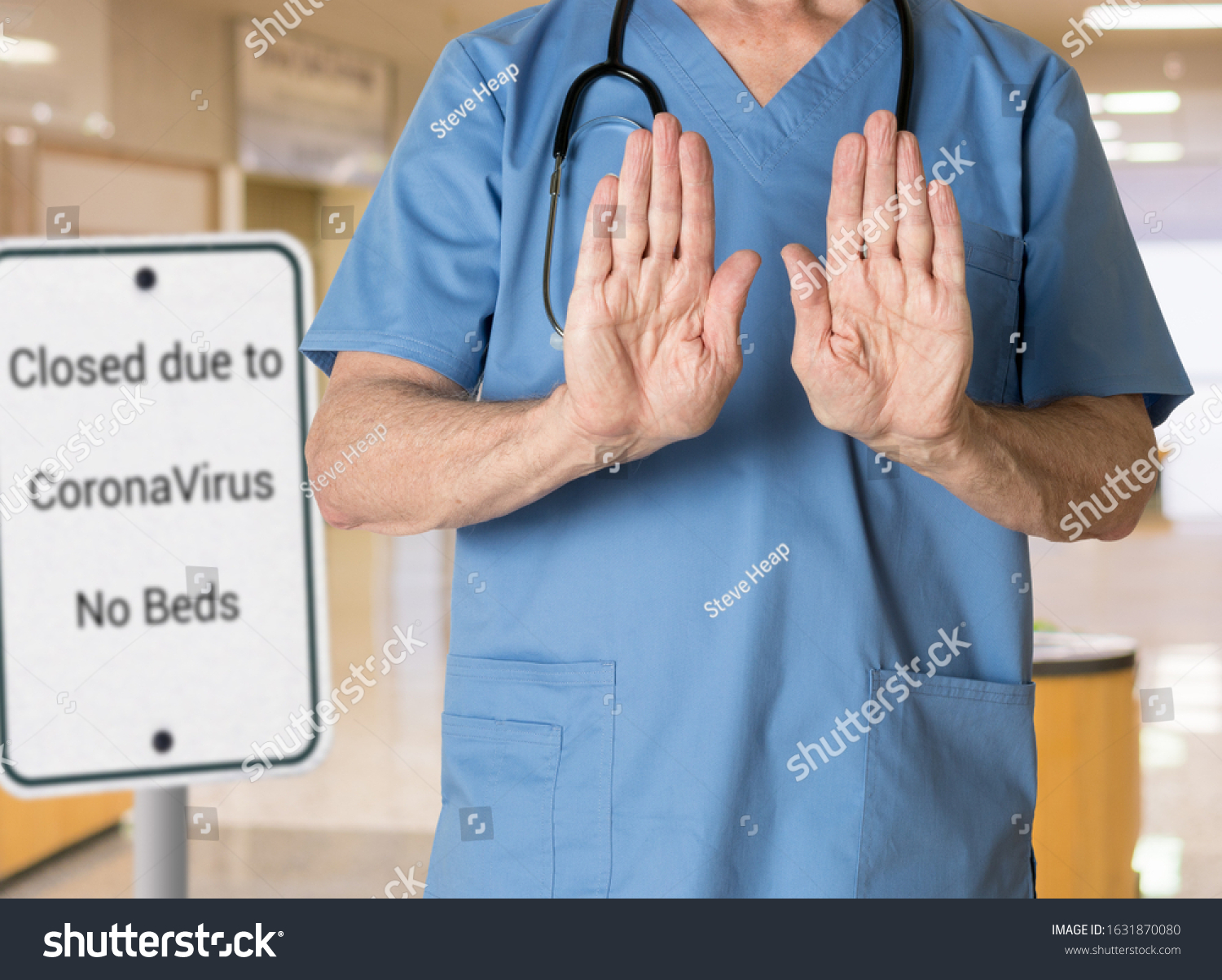 Senior caucasian doctor in scrubs in hospital stopping entry because no beds available because of coronavirus or flu #1631870080