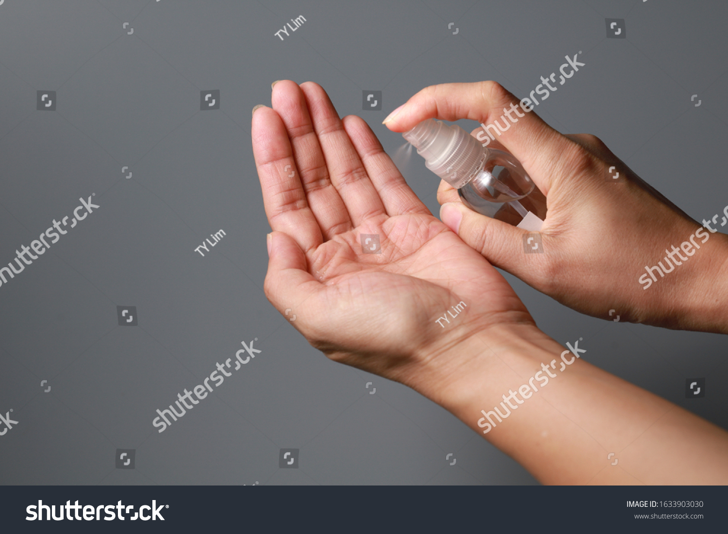 Hand of lady that applying alcohol spray or anti-bacteria spray to prevent the spread of germs, bacteria and virus. Personal hygiene concept.  #1633903030