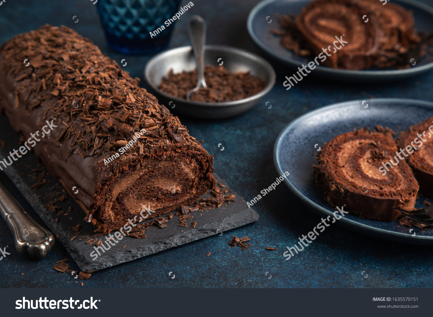 delicious chocolate roll cake with chocolate cream, dark blue background. selective focus #1635570151