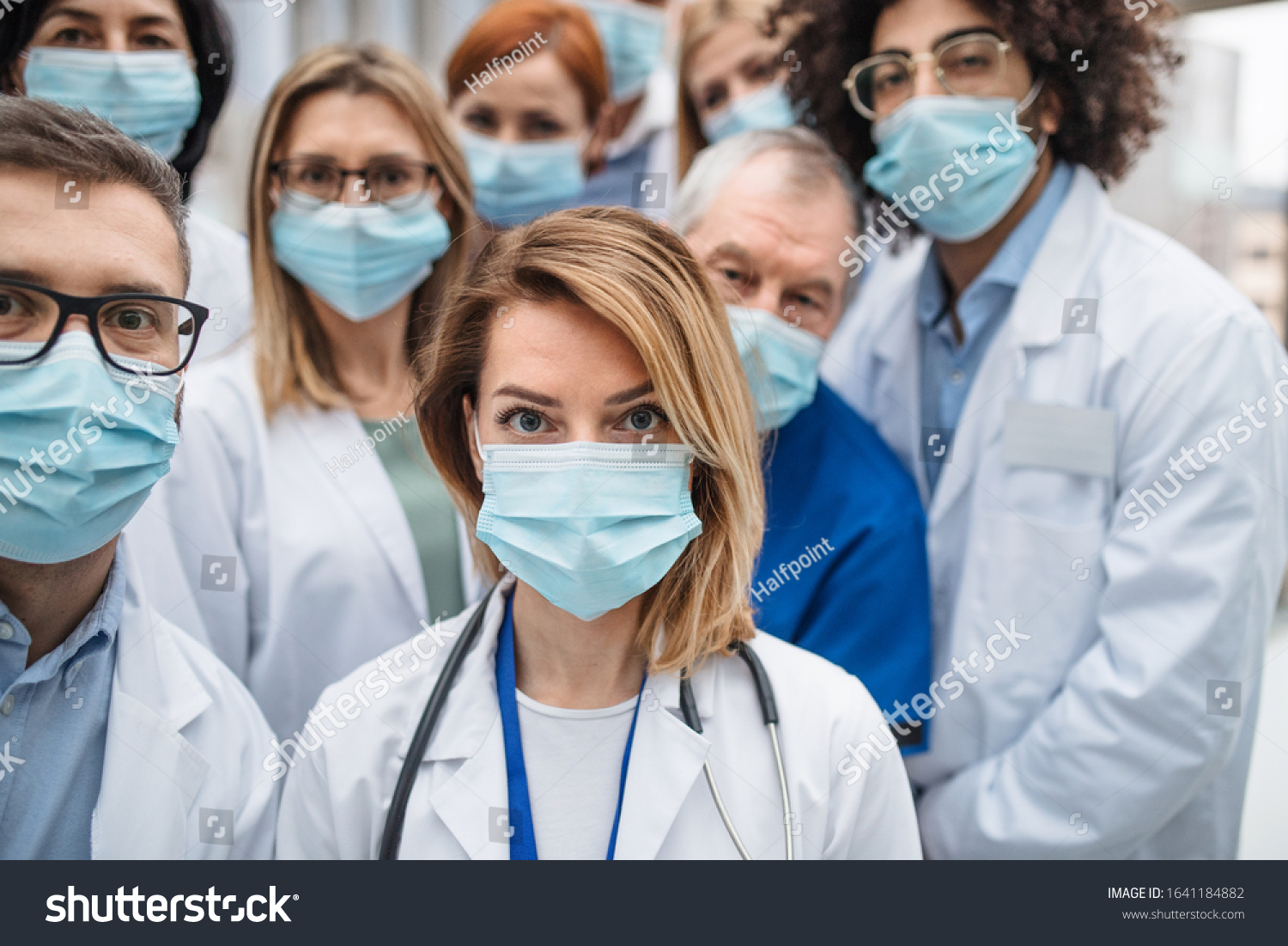 Group of doctors with face masks looking at camera, corona virus concept. #1641184882