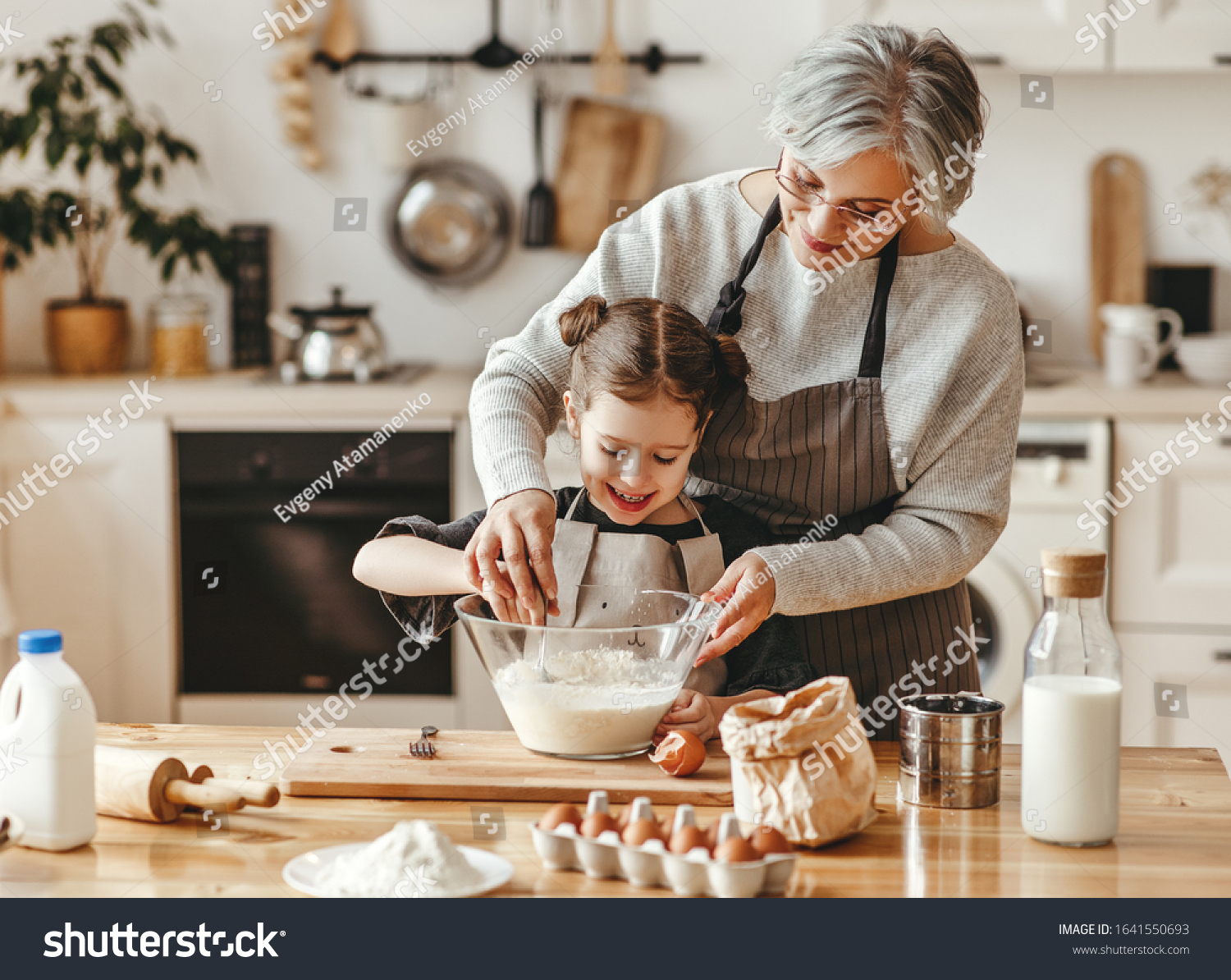 happy family grandmother and granddaughter child  cook in the kitchen, knead dough and bake cookies #1641550693