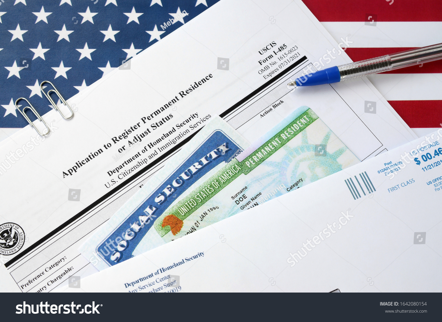 I-485 Application to register permanent residence or adjust status form and green card from dv-lottery with social security number lies on United States flag with USCIS envelope #1642080154