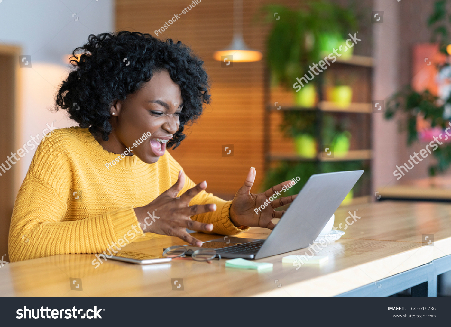 Something went wrong. Angry black businesswoman screaming at laptop screen, working at cafe, copy space #1646616736