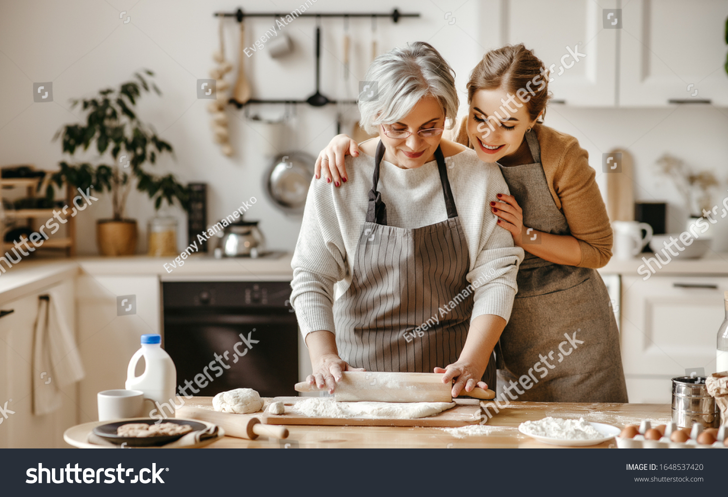 happy family grandmother  old mother mother-in-law and daughter-in-law daughter cook in kitchen, knead dough and bake cookies #1648537420