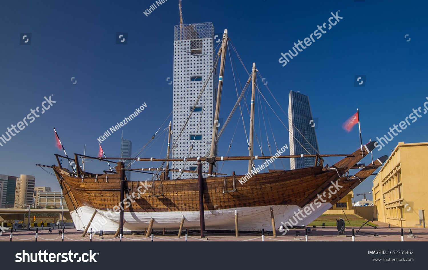 Historic dhow ships view at the Maritime Museum of in Kuwait. Kuwait, Middle East. Skyscrapers on background with blue sky #1652755462