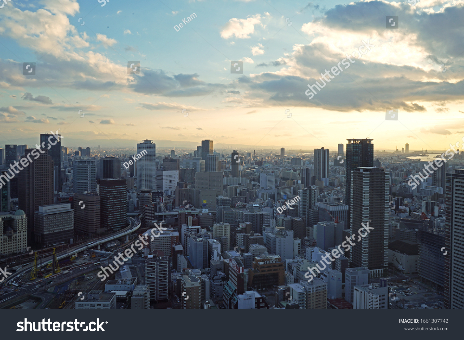 Osaka, Japan - January 9th, 2020: View of sunset in Osaka from Umeda Sky Building. Top view of vertical and dense city of Osaka. #1661307742