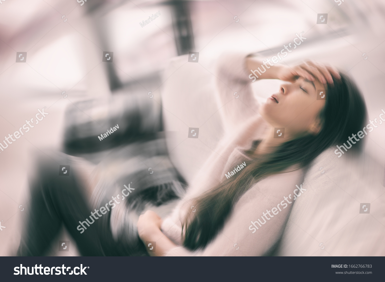 Sick woman with headache feeling faint vertigo holding head in pain with fever and migraine. Blurry motion blur background. #1662766783
