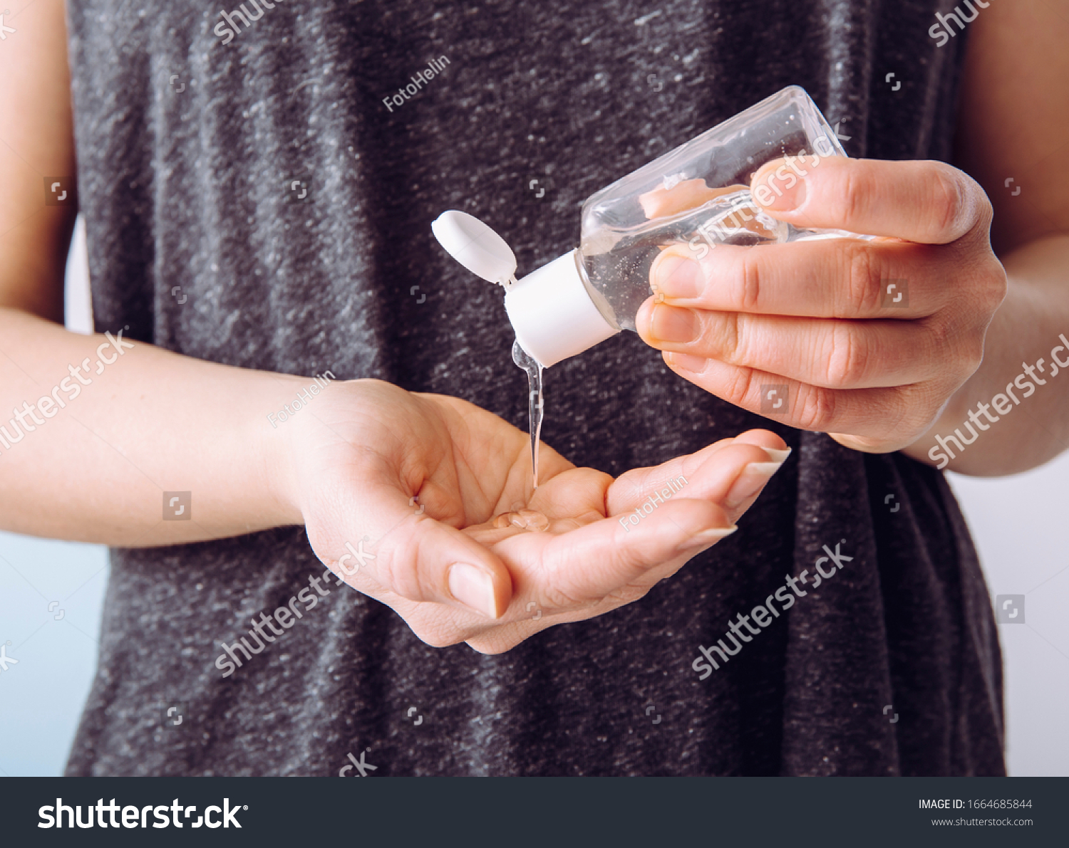 Close up view of woman person using small portable antibacterial hand sanitizer on hands. #1664685844