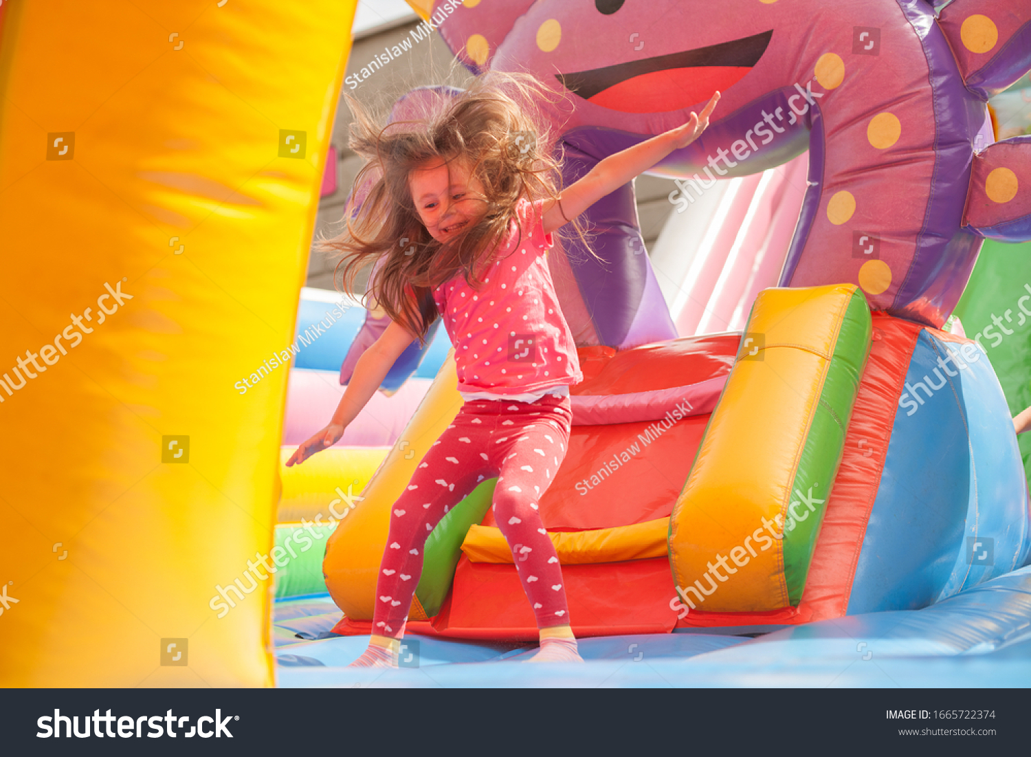 A cheerful child plays in an inflatable castle #1665722374