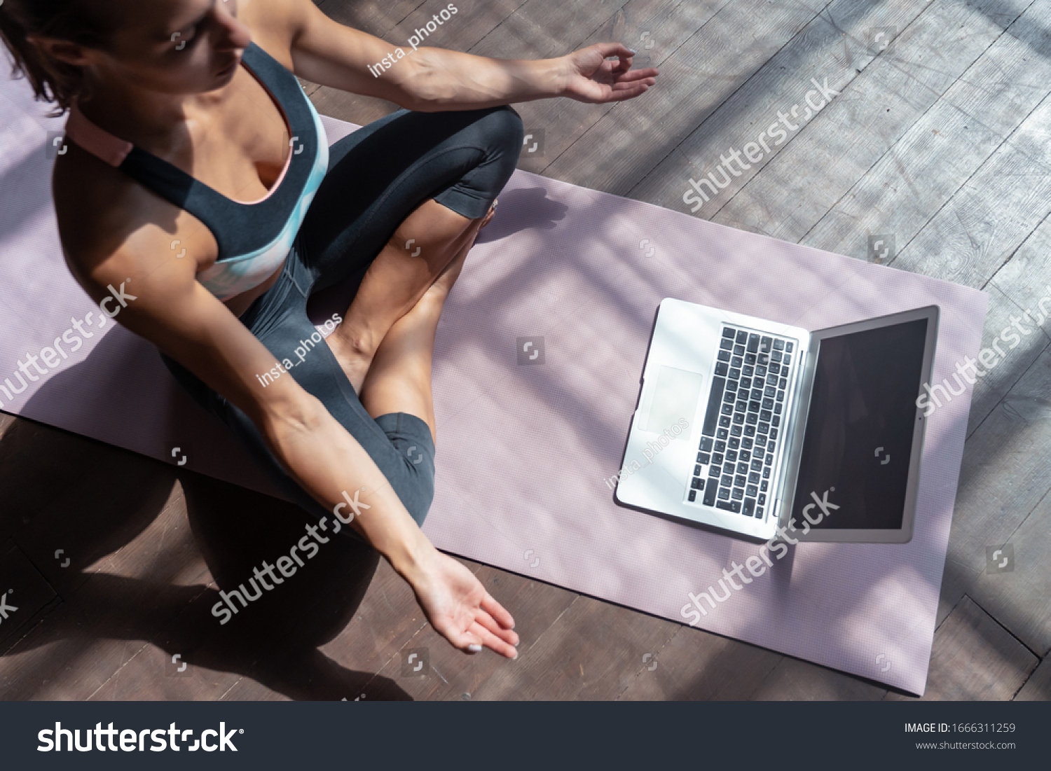 Top view young sporty slim woman coach internet video online training hatha yoga instructor modern laptop screen meditate Sukhasana posture relax breathe easy seat pose gym healthy lifestyle concept. #1666311259