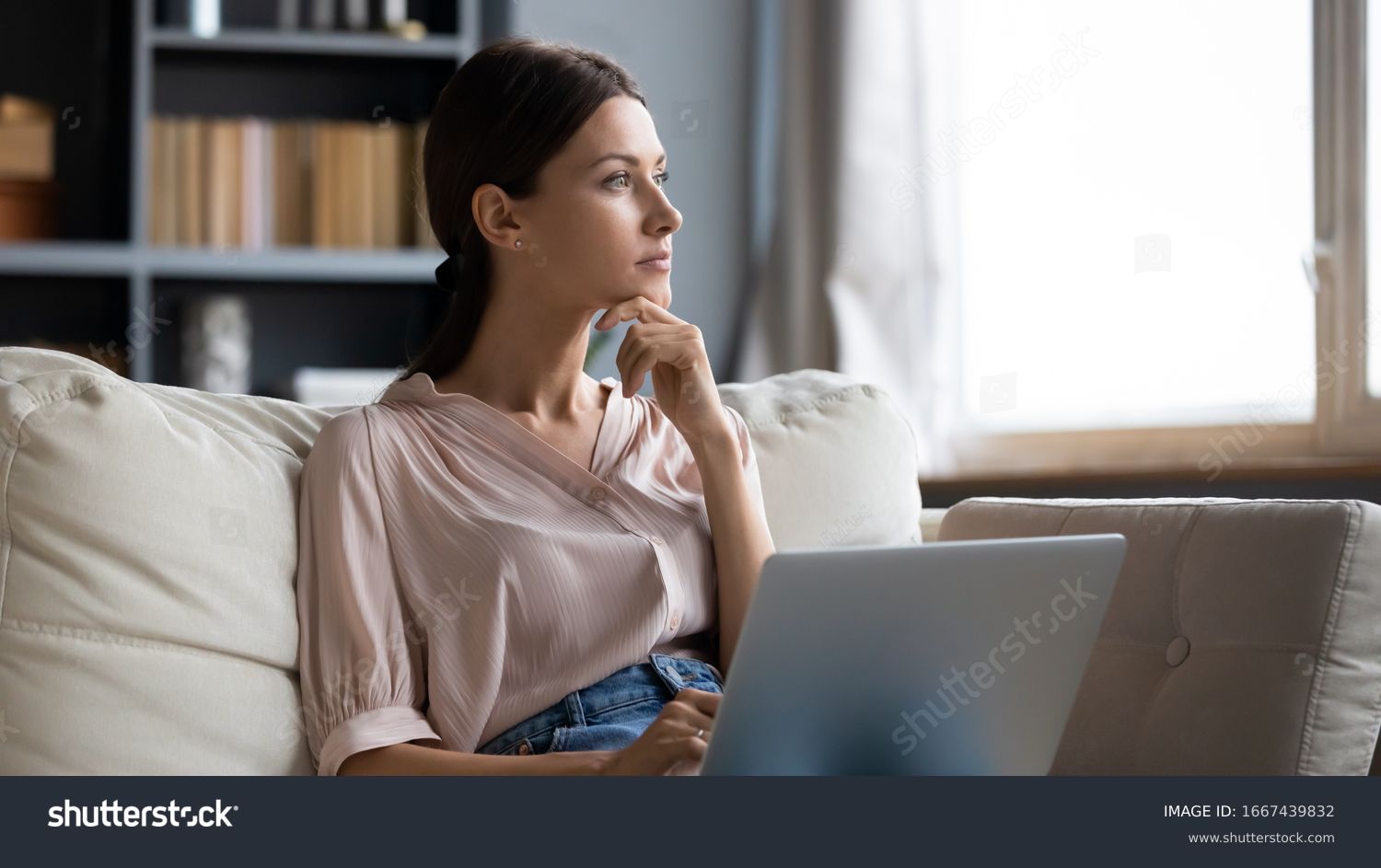 Distracted from work worried young woman sitting on couch with laptop, thinking of problems. Pensive unmotivated lady looking at window, feeling lack of energy, doing remote freelance tasks at home. #1667439832