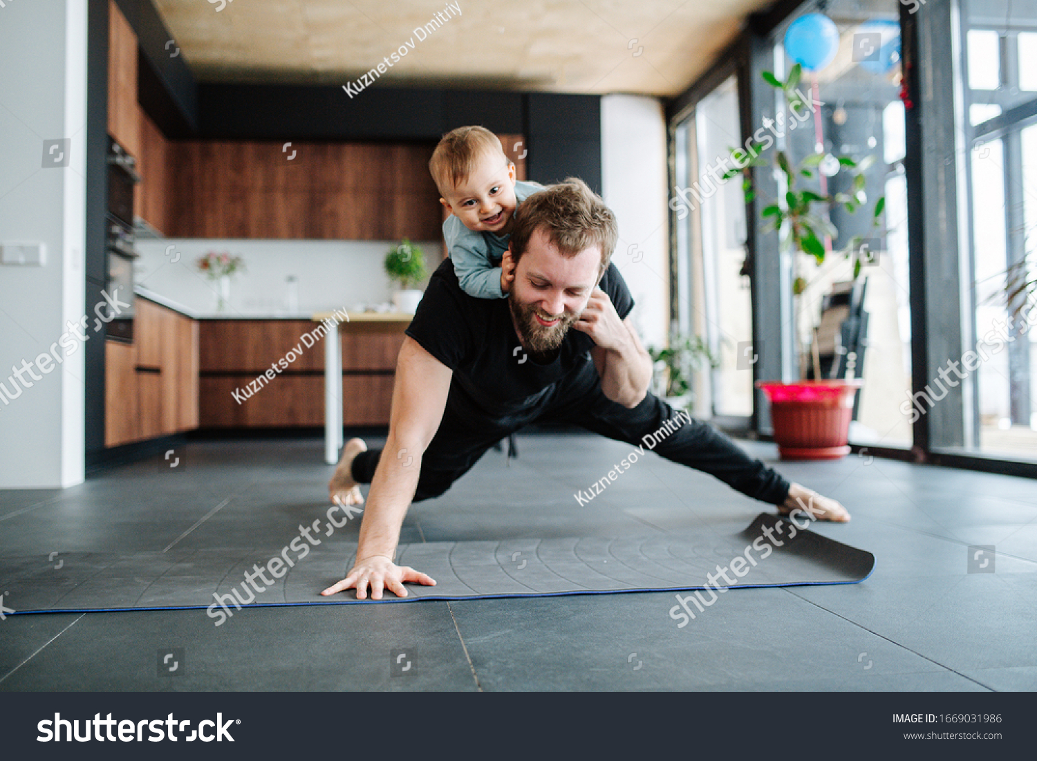 Father working out, doing single arm plank with his jolly infant baby riding on his neck. At home apartment. #1669031986