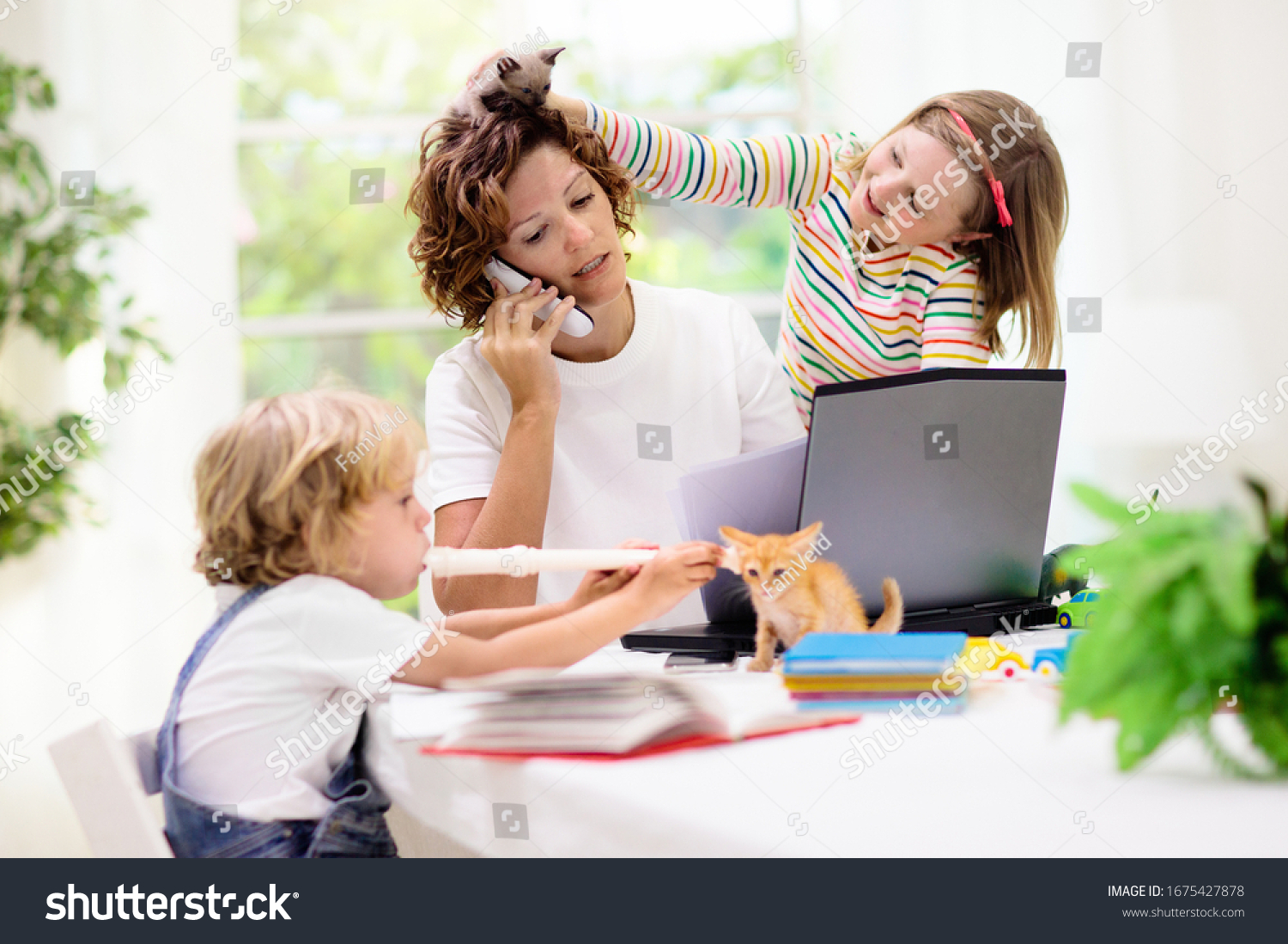 Mother working from home with kids. Quarantine and closed school during coronavirus outbreak. Children make noise and disturb woman at work. Homeschooling and freelance job. Boy and girl playing. #1675427878