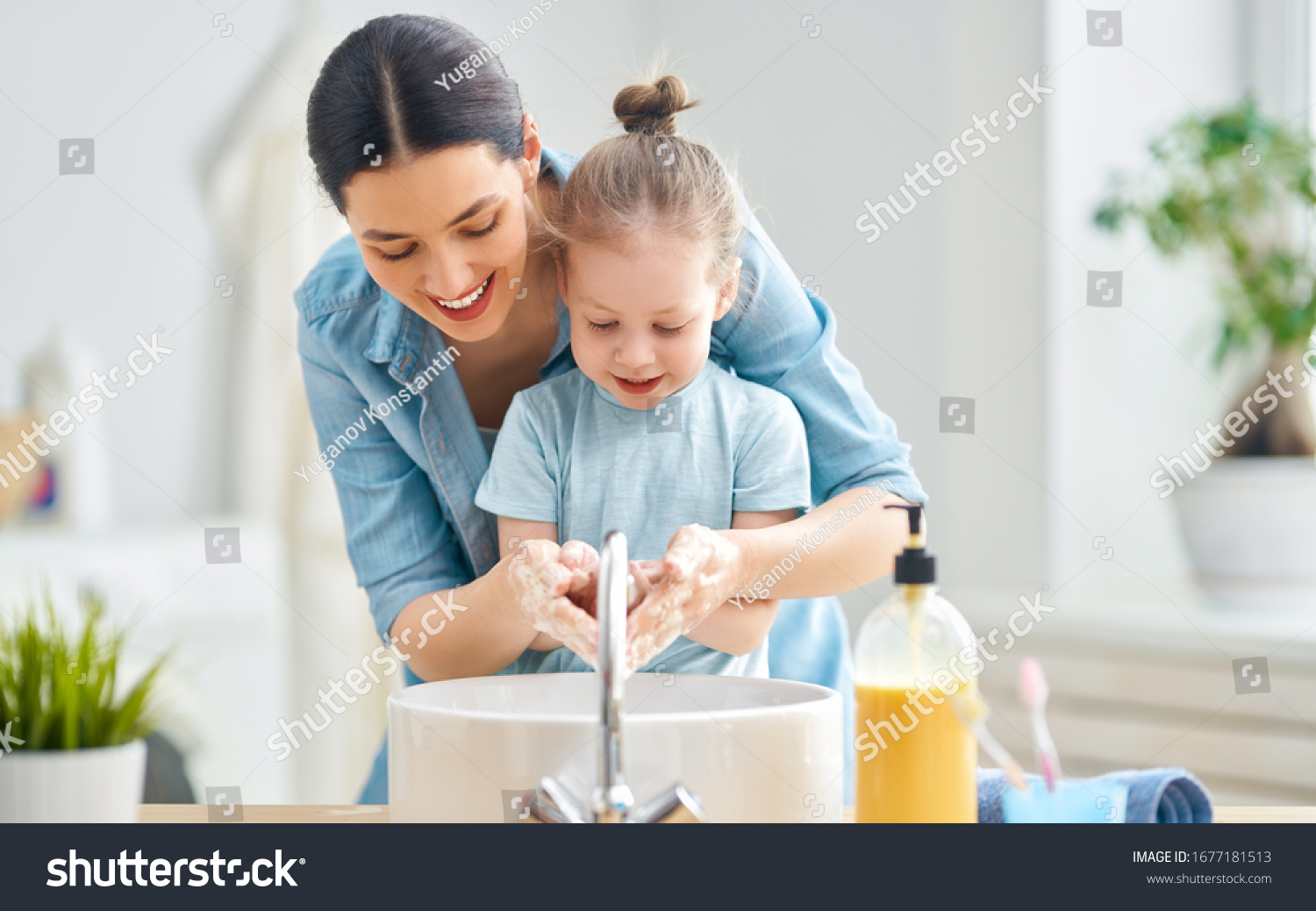 A cute little girl and her mother are washing their hands. Protection against infections and viruses.                                #1677181513