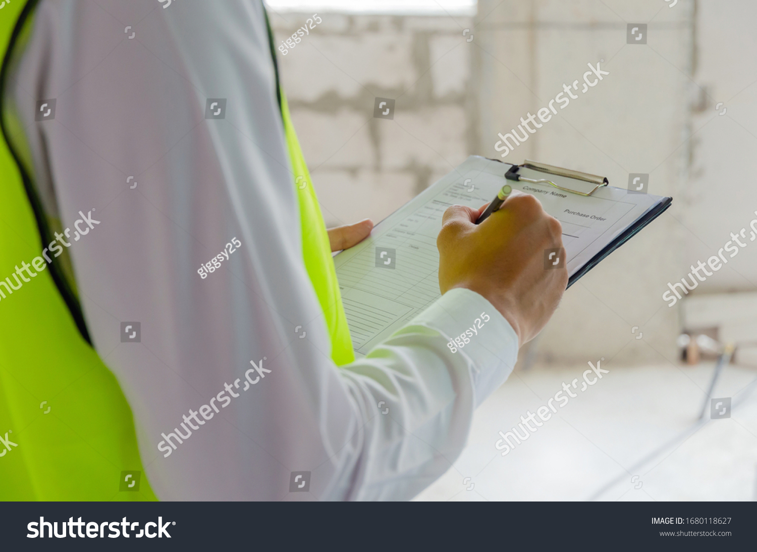 foreman builder, engineer or inspector in green safety vest reflective checking and inspecting with clipboard at construction site building interior, inspection, contractor and engineering concept #1680118627