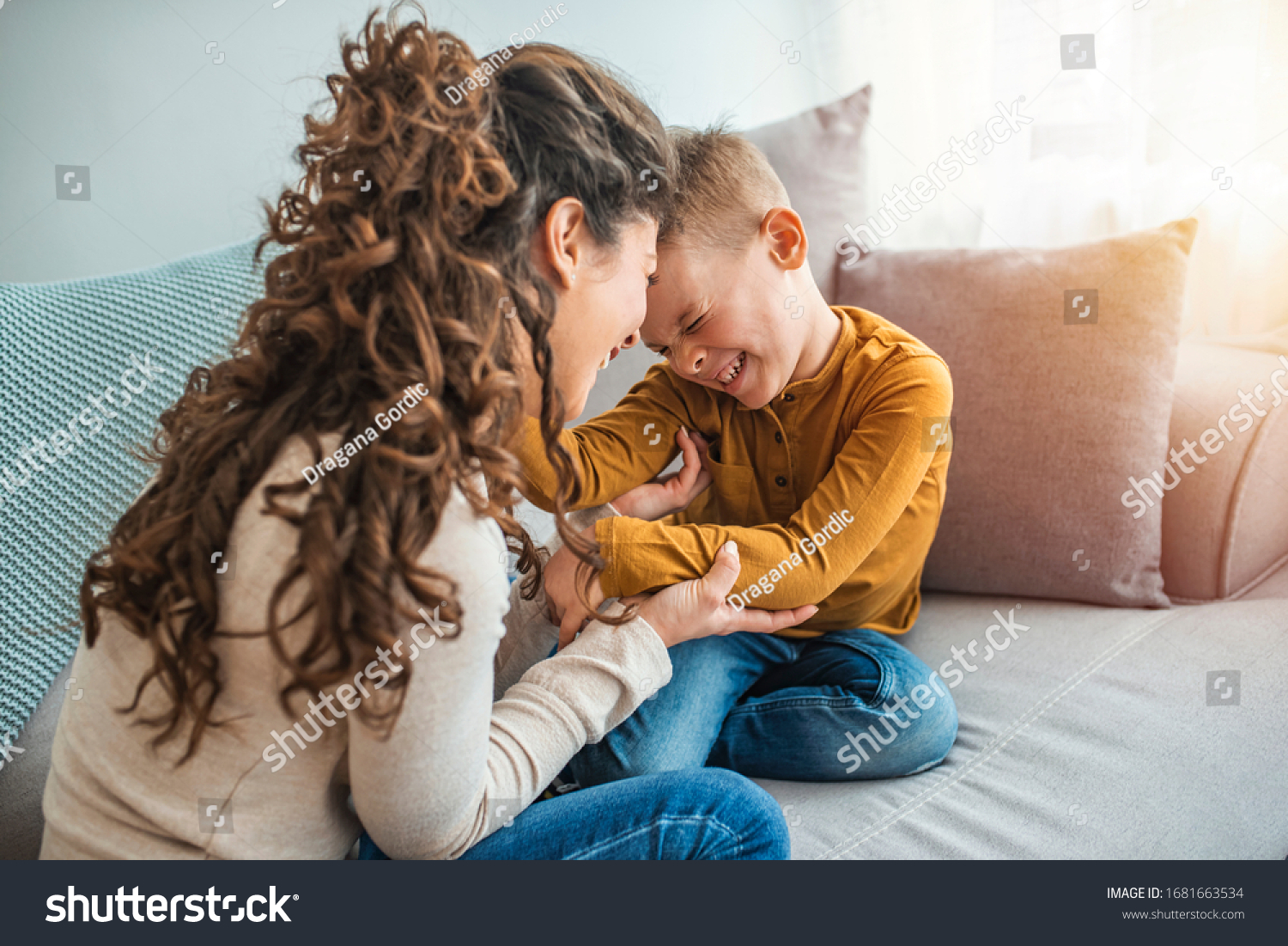 The kind of love that can't be described, only felt. Mother and her child, tickling, kidding and having fun in the couch, with spontaneous smiles. Loving my son  #1681663534