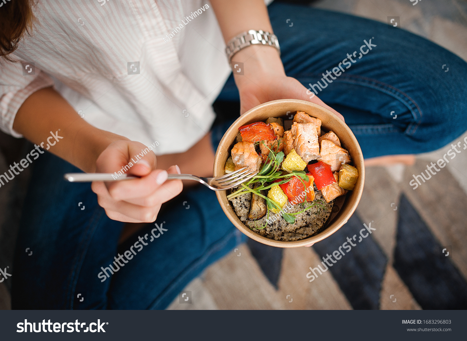 Girl holds a paper plate with healthy food sitting on the floor. Home delivery food. Healthy eating concept. When you stay at home. #1683296803