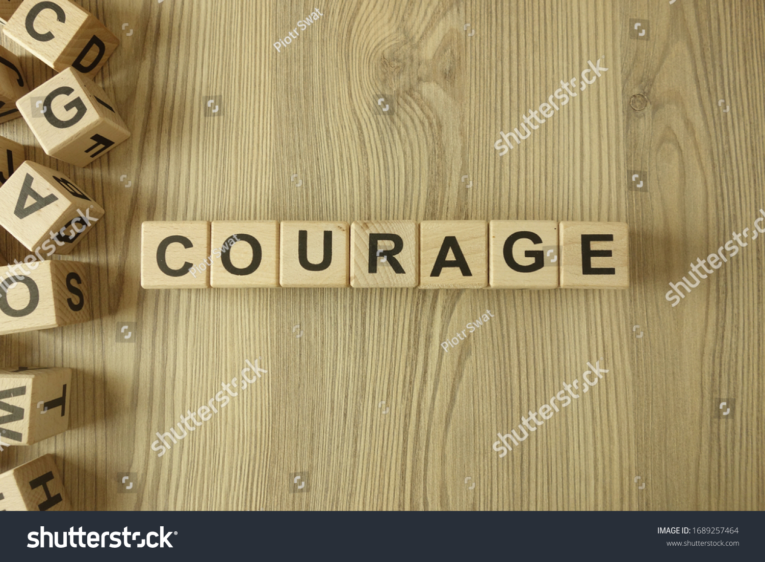 Word courage from wooden blocks on desk #1689257464