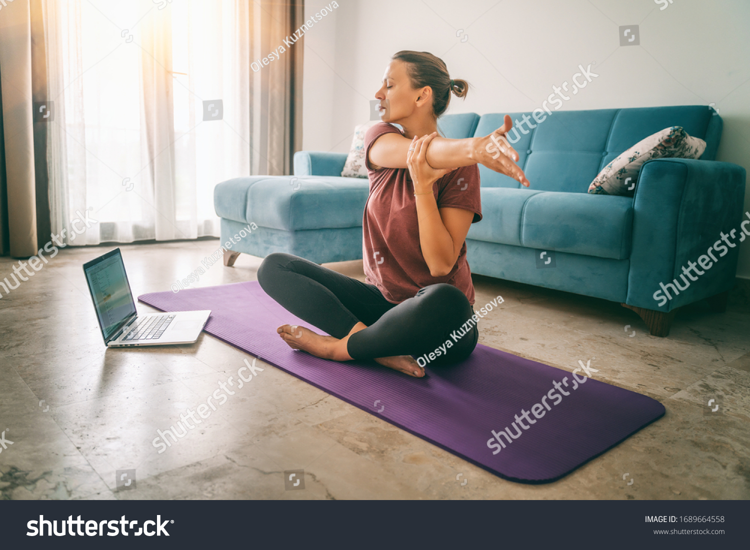 Attractive young woman doing yoga stretching yoga online at home. Self-isolation is beneficial, entertainment and education on the Internet. Healthy lifestyle concept. #1689664558