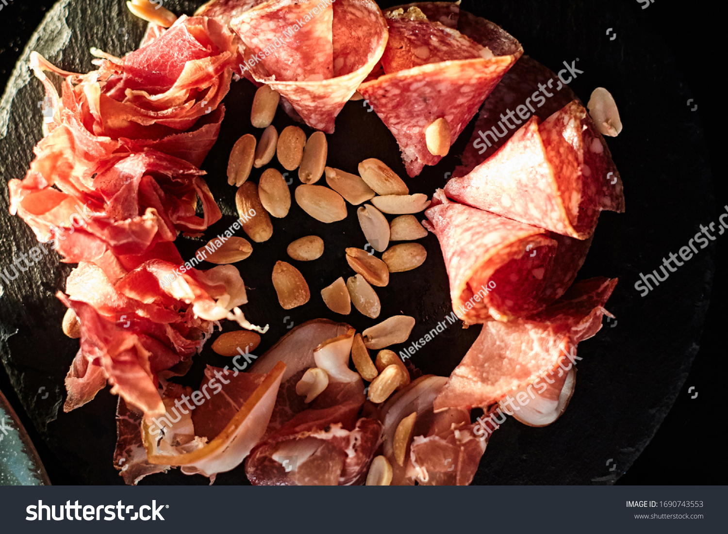 sliced meat and peanuts on a board #1690743553