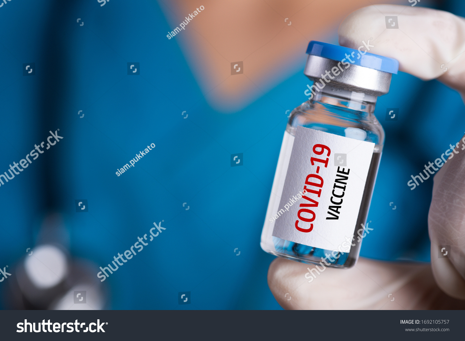 Female doctor with a stethoscope on shoulder holding syringe and COVID-19 vaccine. Healthcare And Medical concept. #1692105757