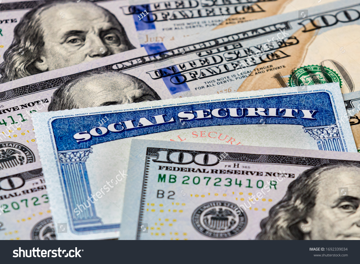 Closeup of Social Security benefits identification card with 100 dollar bills #1692339034