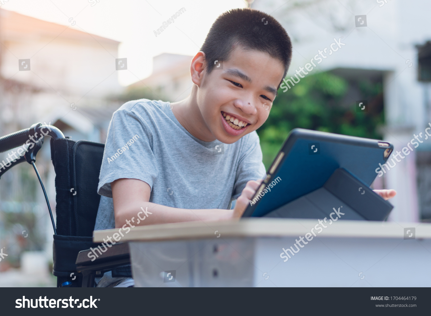 Disabled child on wheelchair happy time to use a tablet in the house, Study and Work at home for safety from covid 19, Life in the education age of special need kid, Happy disability boy concept. #1704464179