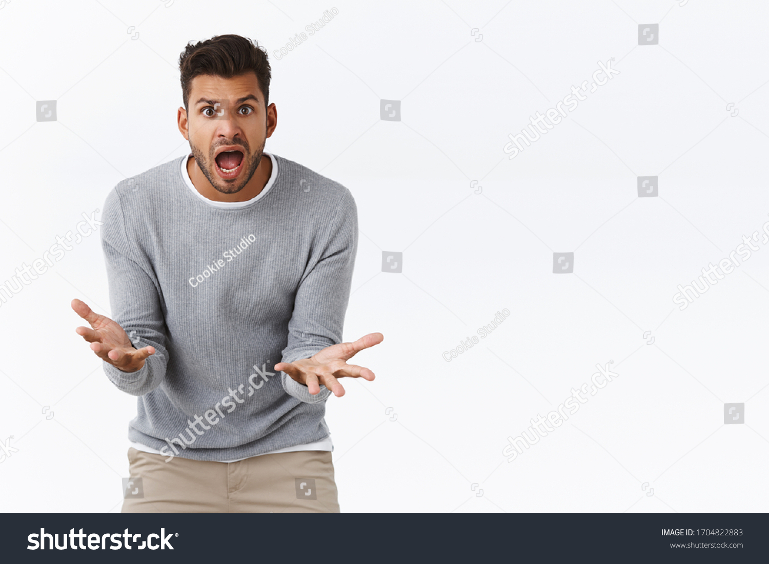 Man was let down yelling at friend how could he betray him, shaking hands in dismay and outraged, standing troubled and frustrated, standing white background bothered, cant figure out what problem #1704822883
