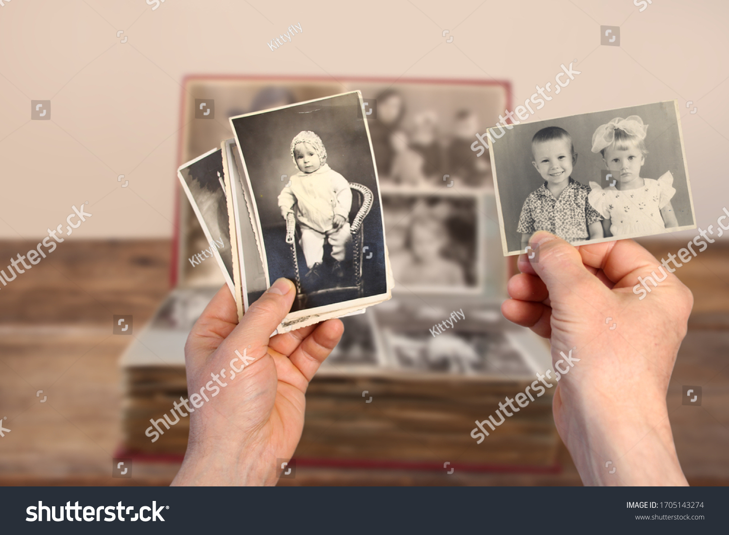male hands holding an old retro album with vintage monochrome photographs in sepia color 1964-1965, the concept of genialogy, memory of ancestors, family ties, childhood memories #1705143274