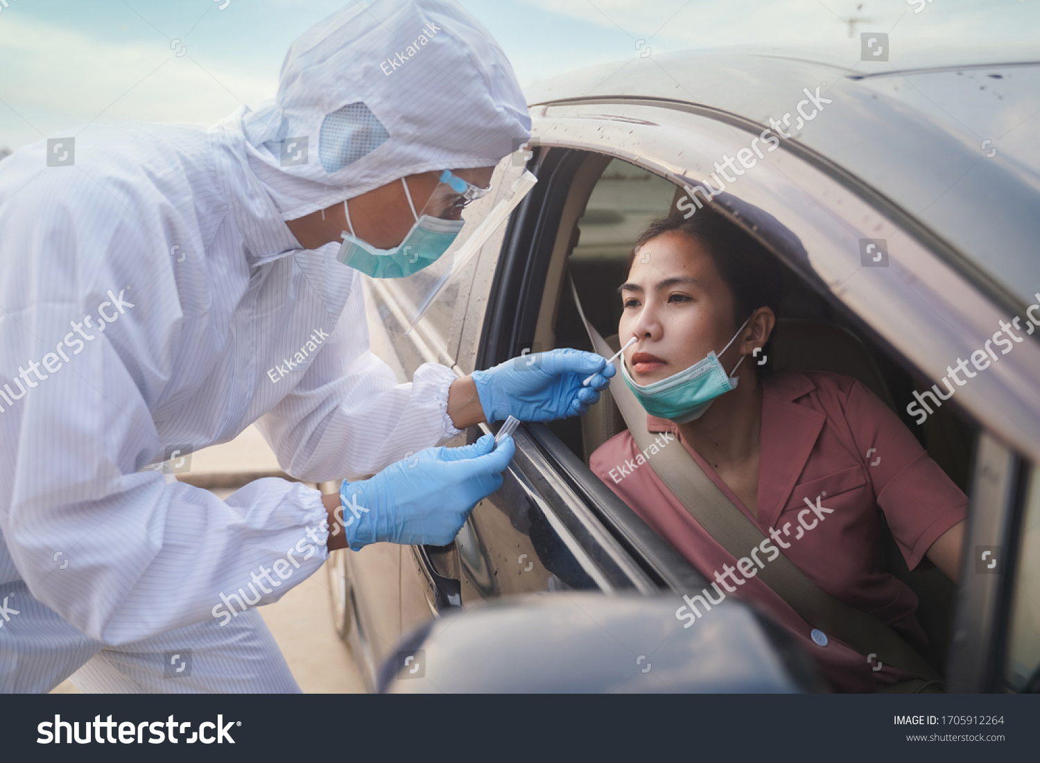 Medical worker in protective suit screening woman Driver to Sampling secretion to check for Covid-19. Drive thru test coronavirus fast track. Concept prevention coronavirus outbreak. #1705912264