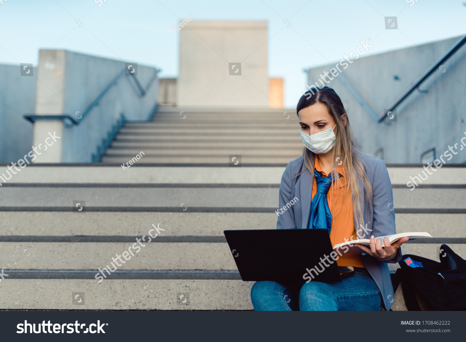 Student woman sitting on empty stairs of university campus working #1708462222