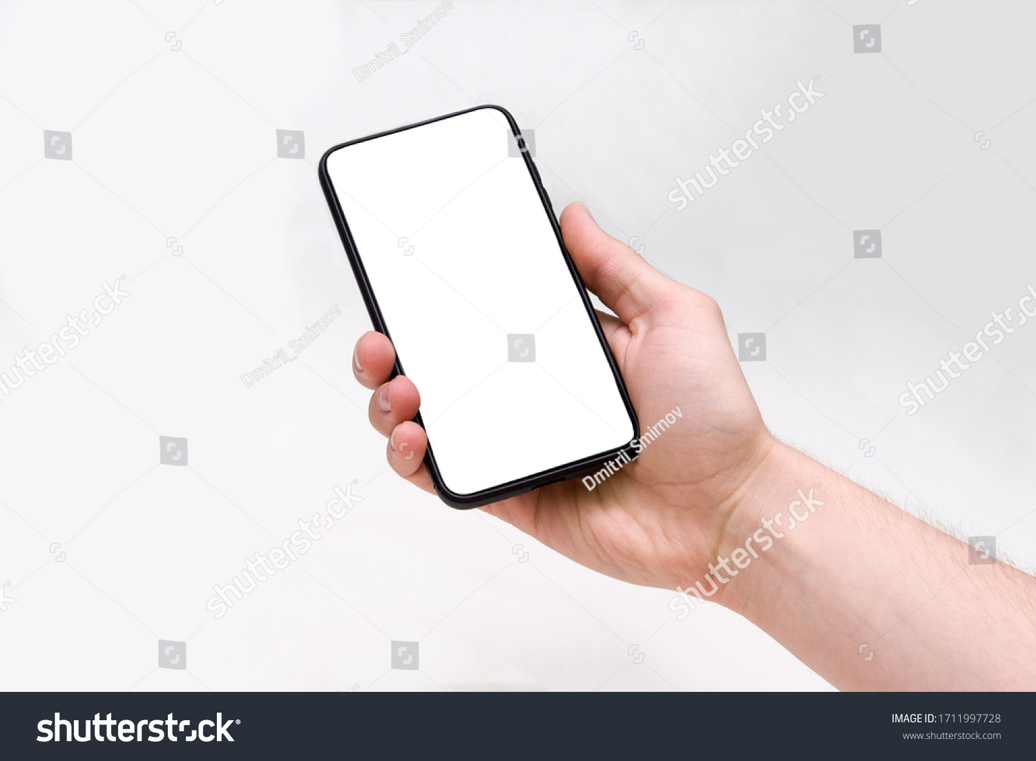 Man holding smartphone with blank screen on white background, closeup of hand. Space for text #1711997728