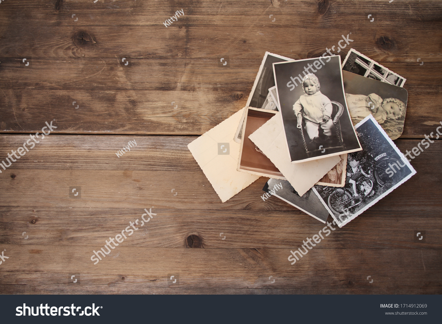 old vintage monochrome photographs, pictures taken in 1968, in sepia color are scattered on a wooden table, concept of genealogy, the memory of ancestors, family ties, memories of childhood #1714912069
