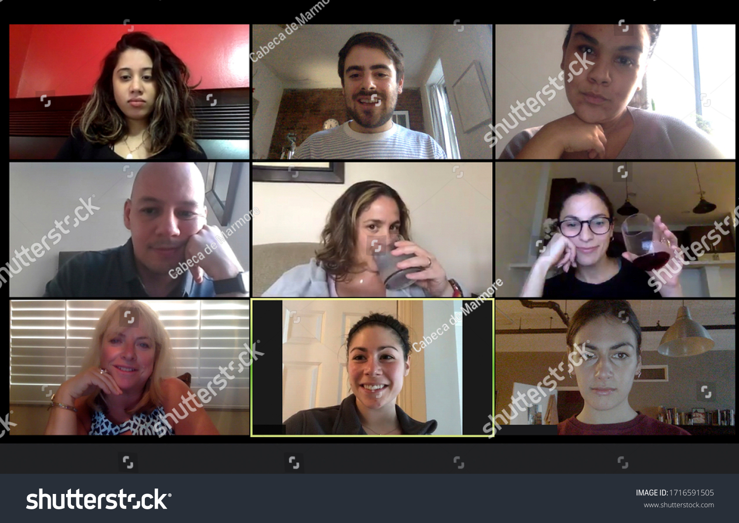 Shot of a screen of teammates doing a virtual happy hour from their home offices.  Team meeting from home during COVID-19 coronavirus pandemic. #1716591505