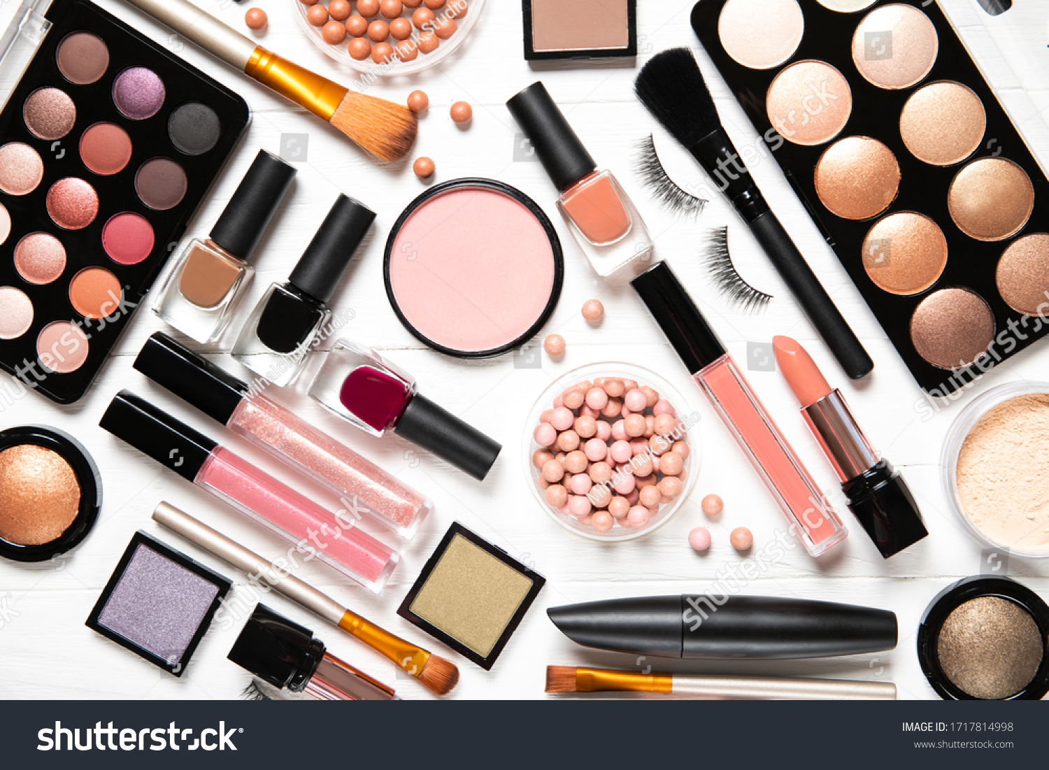 Decorative cosmetics and makeup brushes on a white background, top view #1717814998