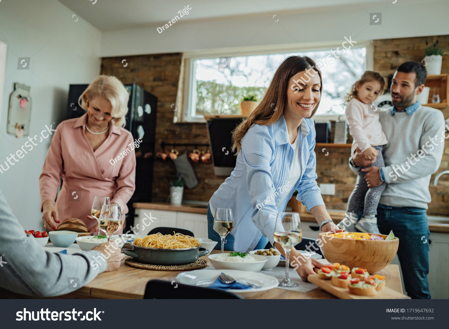 Young happy woman setting dining table for family lunch at home.  #1719647692