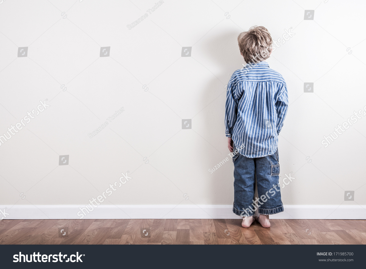 Boy standing up against a wall #171985700