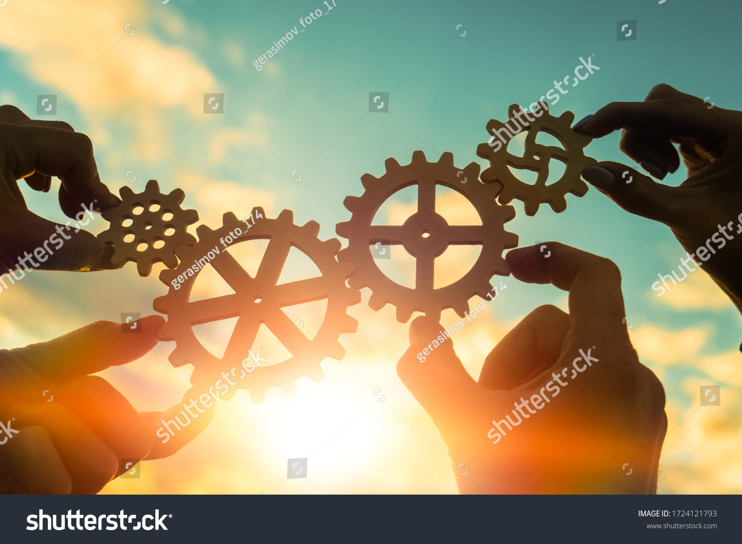 Four hands of businessmen connect gears to a puzzle on a background of sunset. Business concept idea, partnership, cooperation, teamwork, community, creative #1724121793