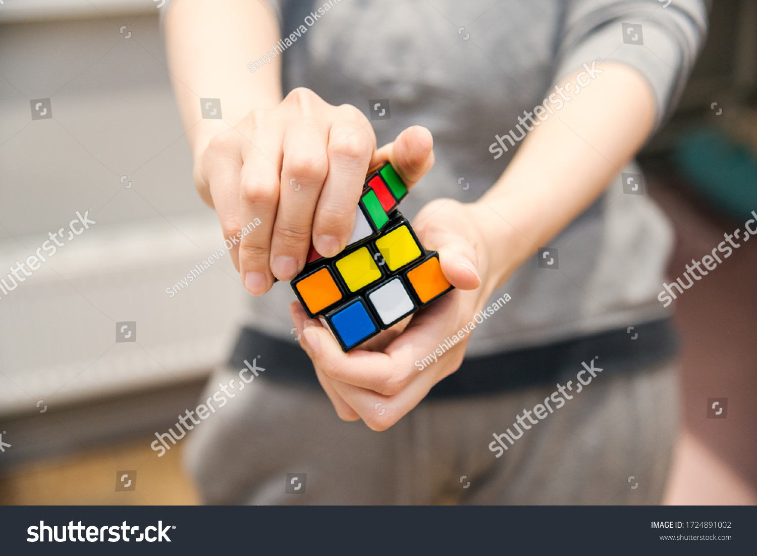 female hands holding a rubik's cube #1724891002