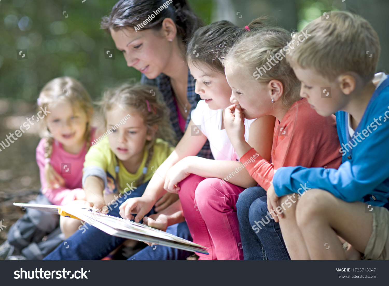 Kindergarten teacher reading with kids in a wood kindergarten #1725713047