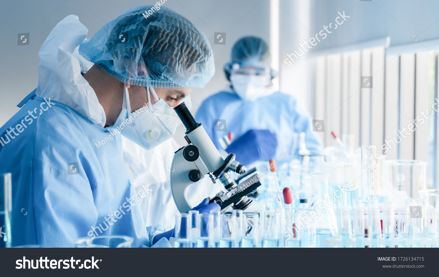 biochemical research scientist team working with microscope for coronavirus vaccine development in pharmaceutical research labolatory, selective focus #1726134715